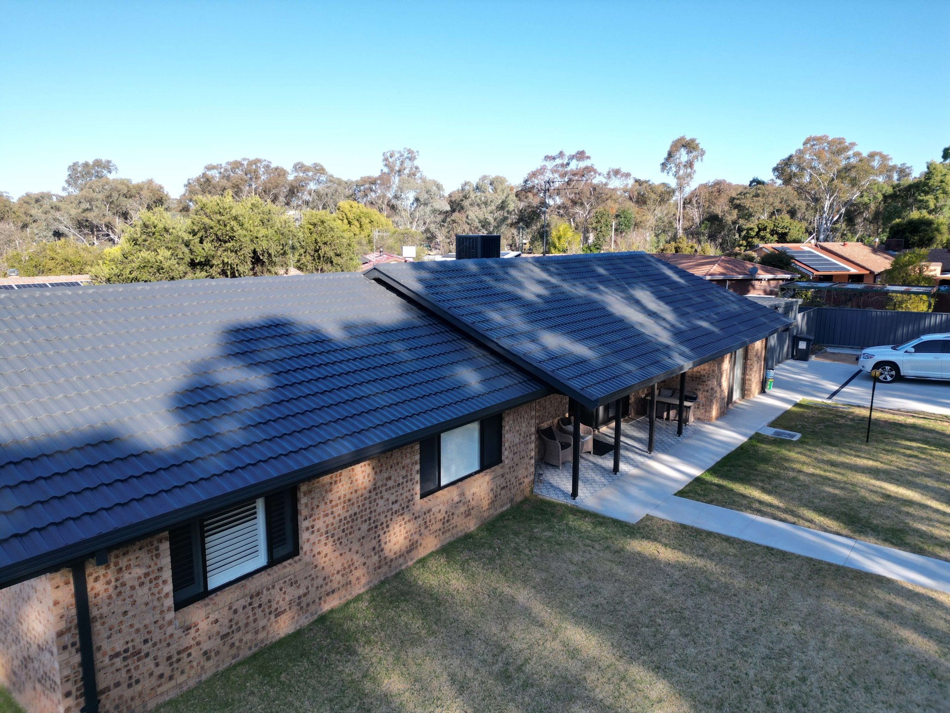 Aerial view of a Coonabarabran brick home with a freshly painted charcoal profiled tile roof