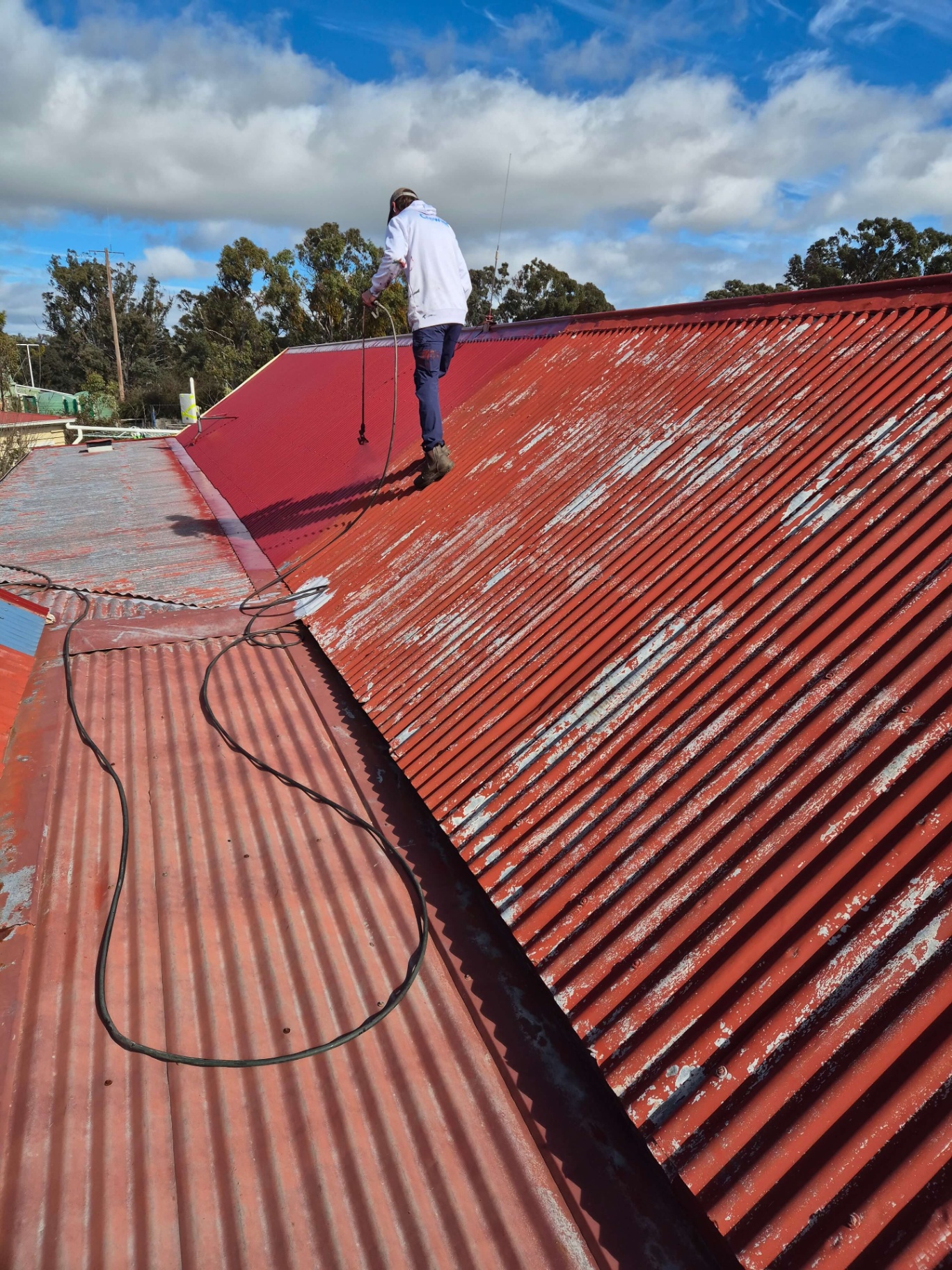 Roof Painting Plus Painter Airless Spraying a Corrugated Iron Roof in Manor Red