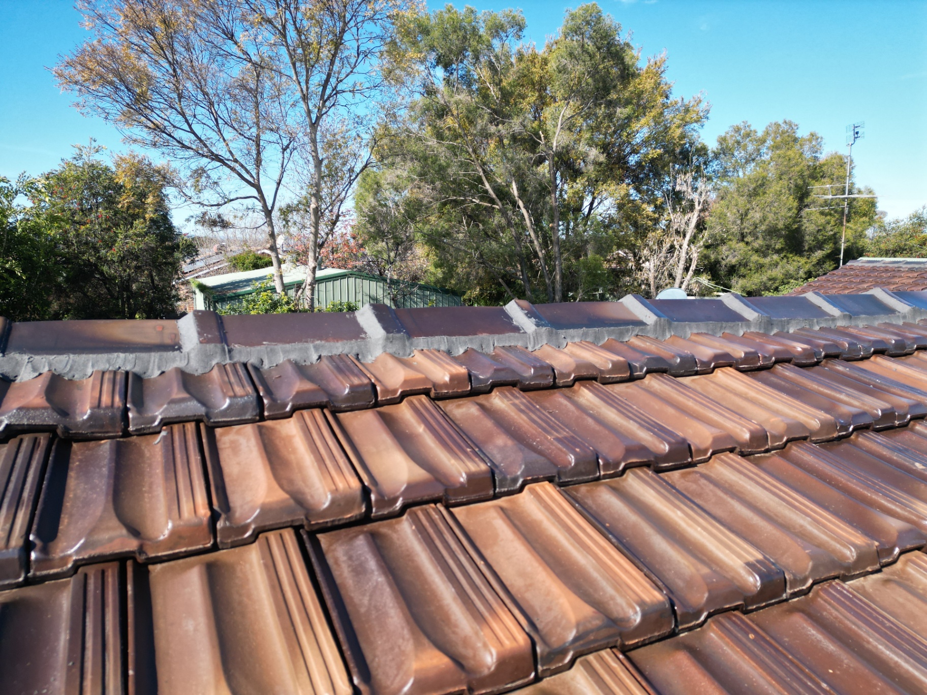 Completed Ridge Line on a Brown Tile Roof With Straight, Cleanly Tooled Flexible Pointing