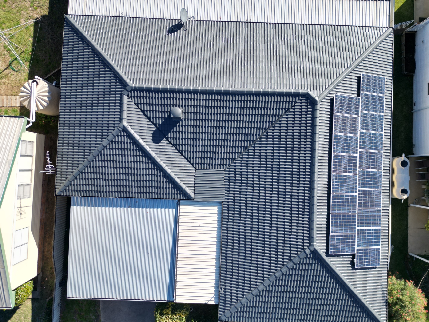 Top-down aerial view of a Coonabarabran home with a freshly restored charcoal tile roof and solar array