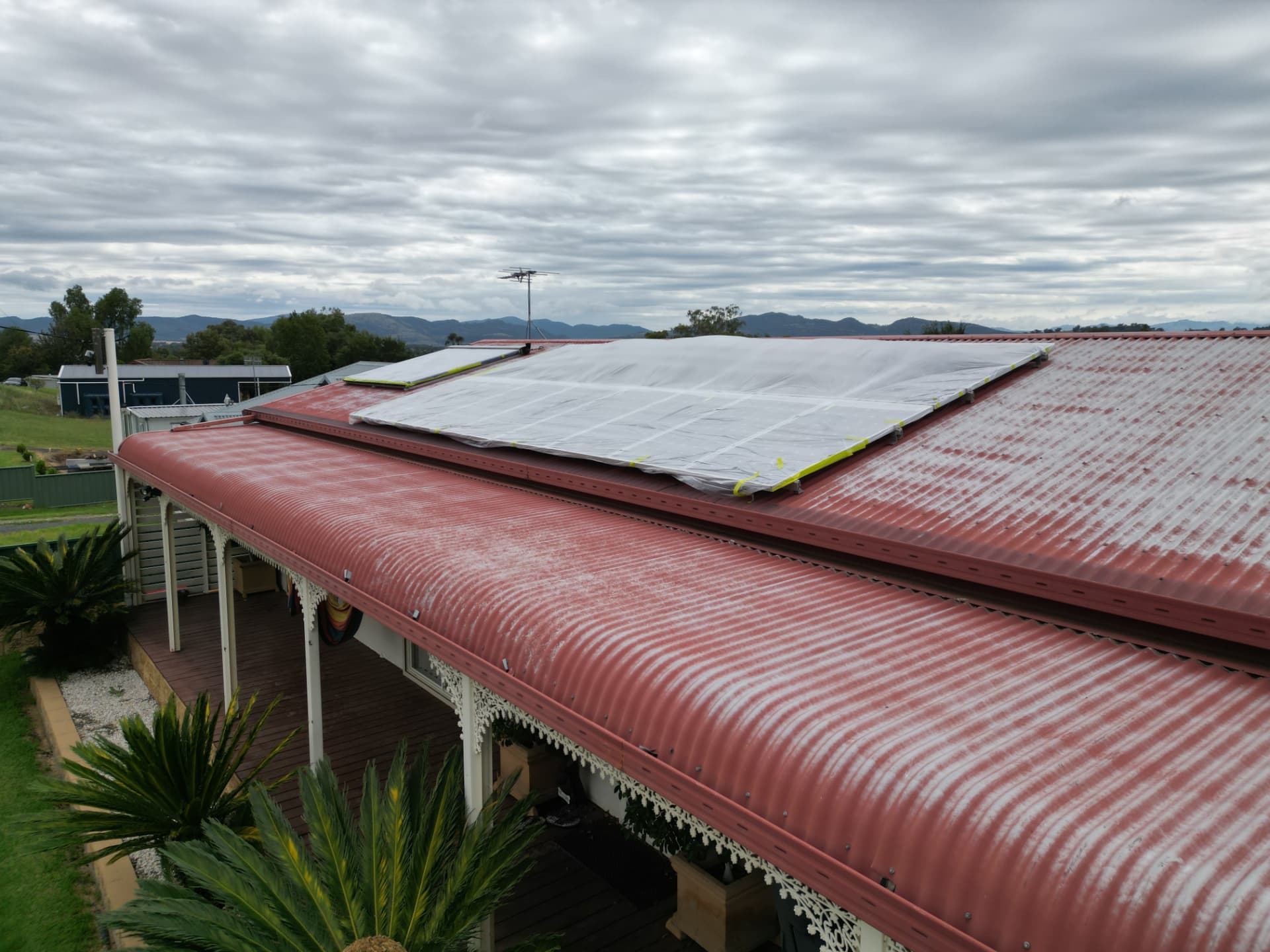 Quirindi corrugated metal roof faded and rust-stained before restoration, with solar panels installed