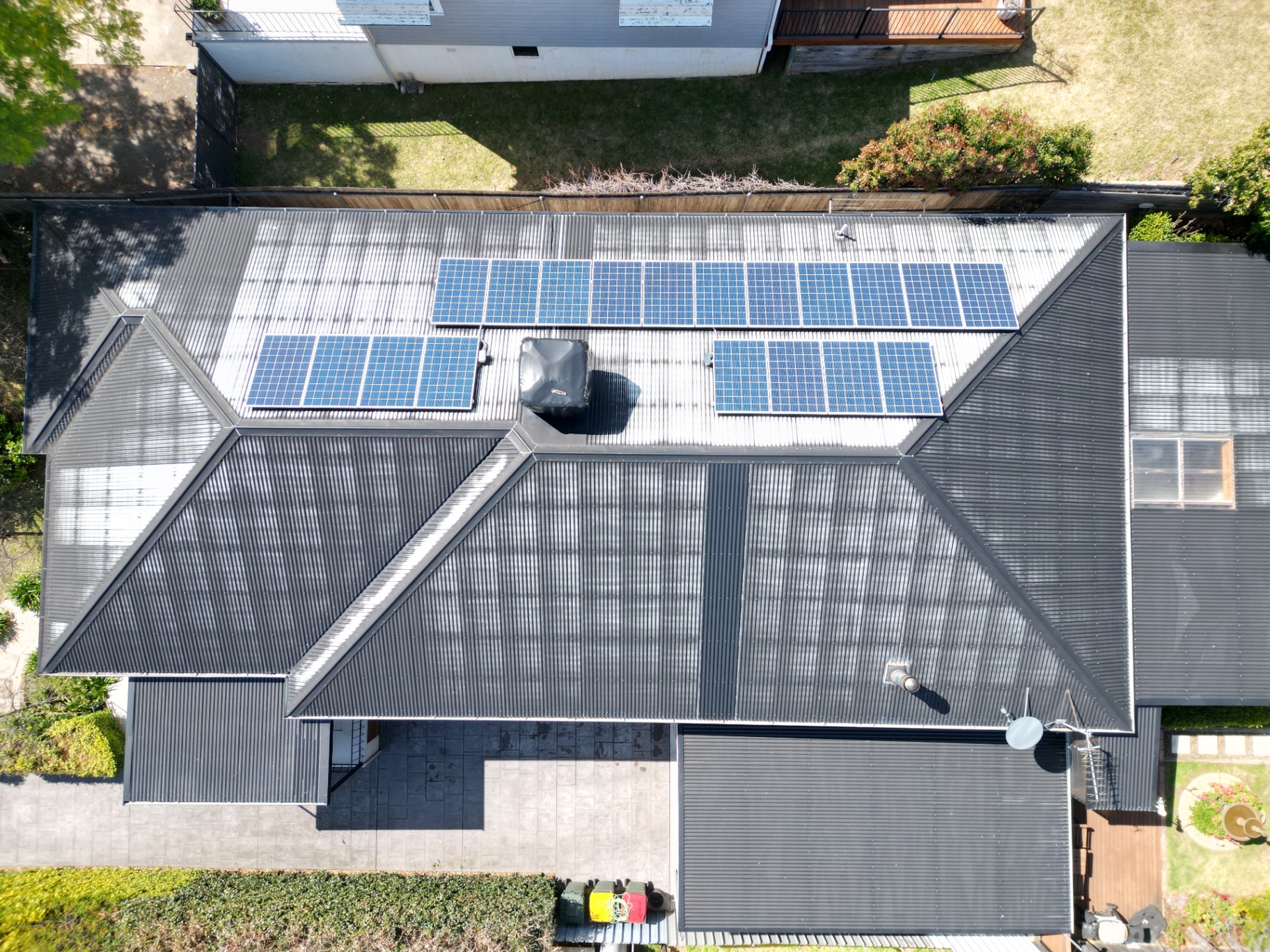 Aerial view of a faded, patchy Tamworth Colorbond roof with solar panels before repainting