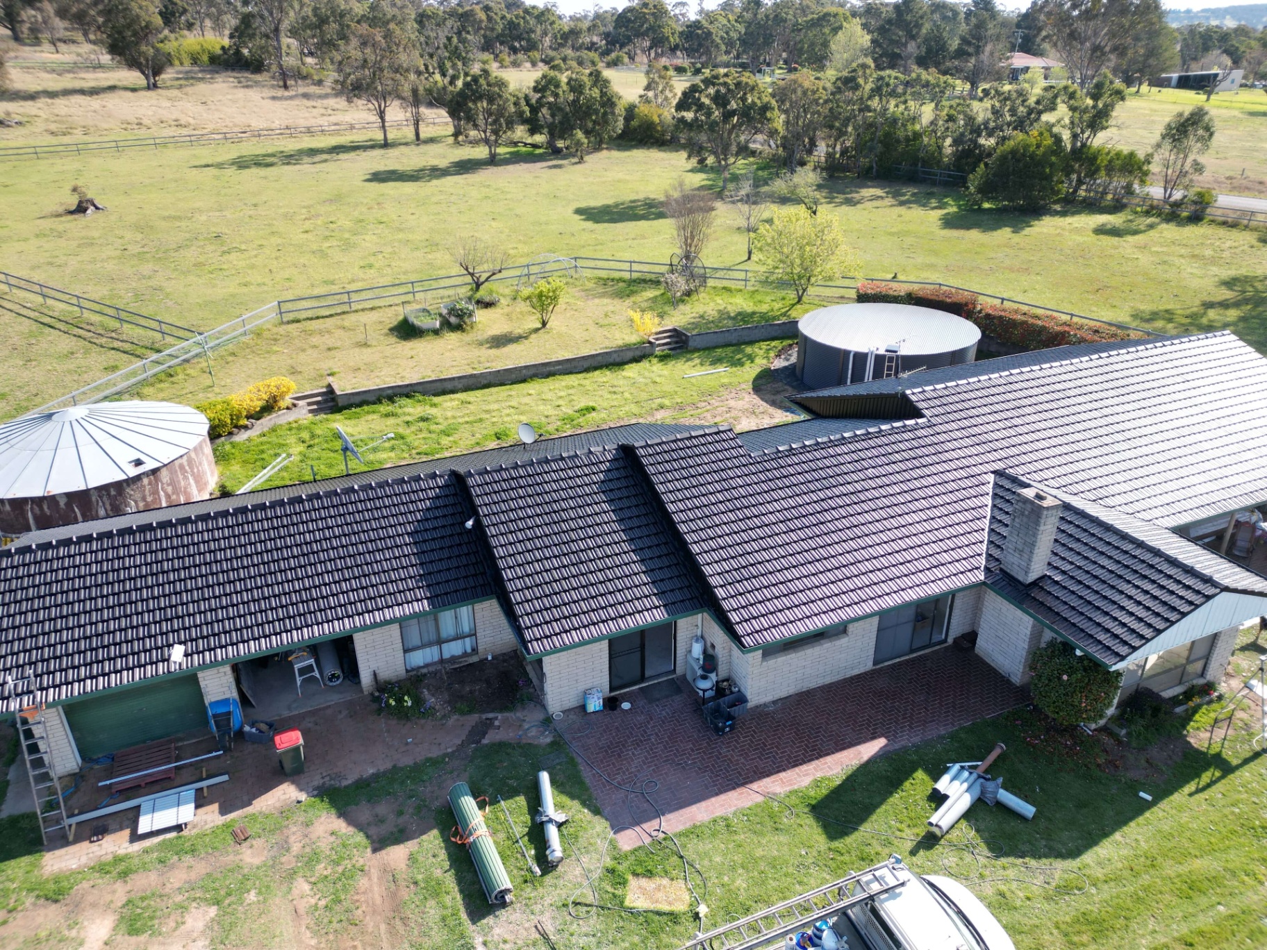 Aerial view of an Armidale farmhouse with a freshly restored deep black profiled tile roof