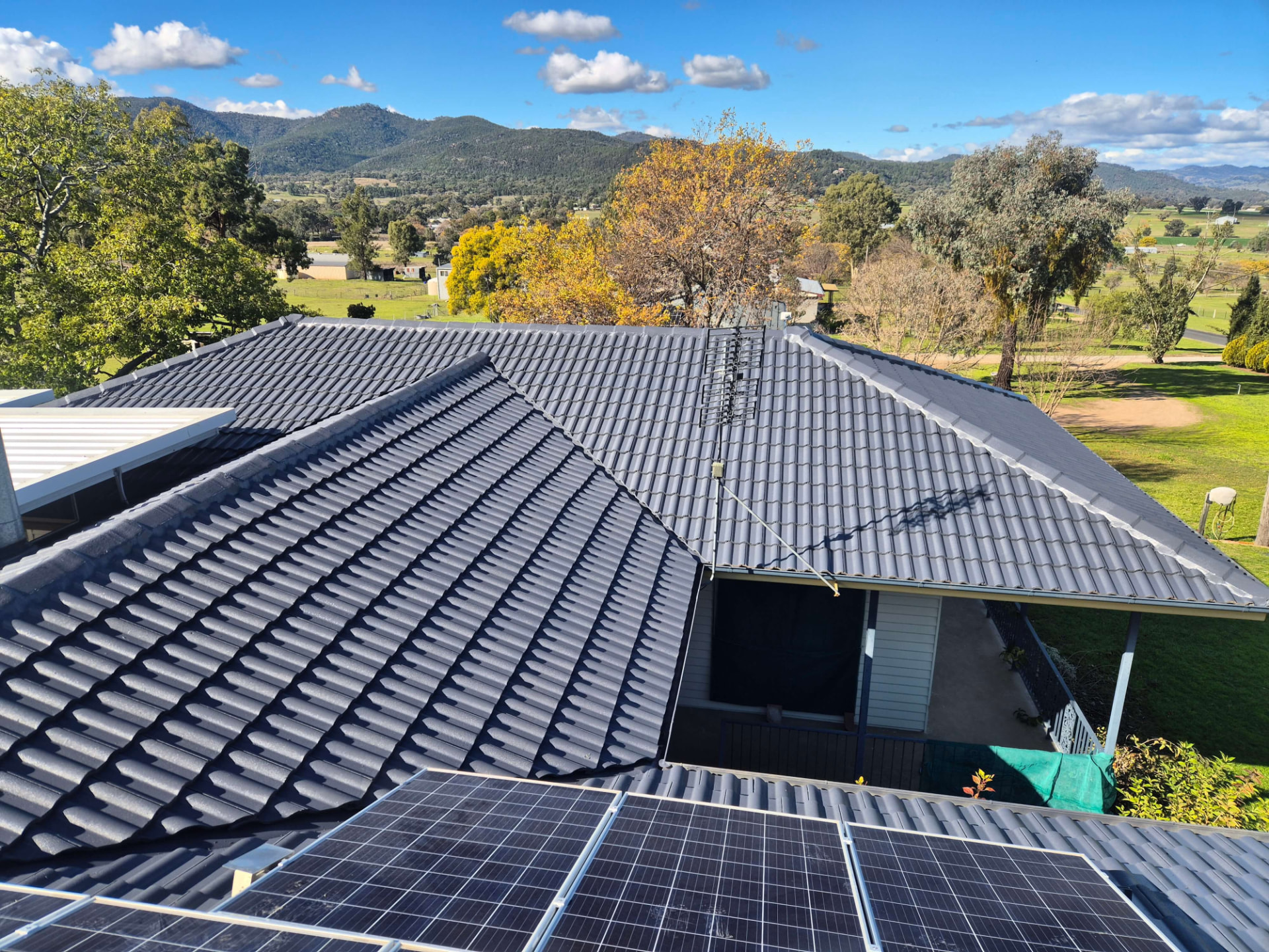 Restored Charcoal Tile Roof With Solar Panels and the Ranges Behind, Photographed From the Ridge