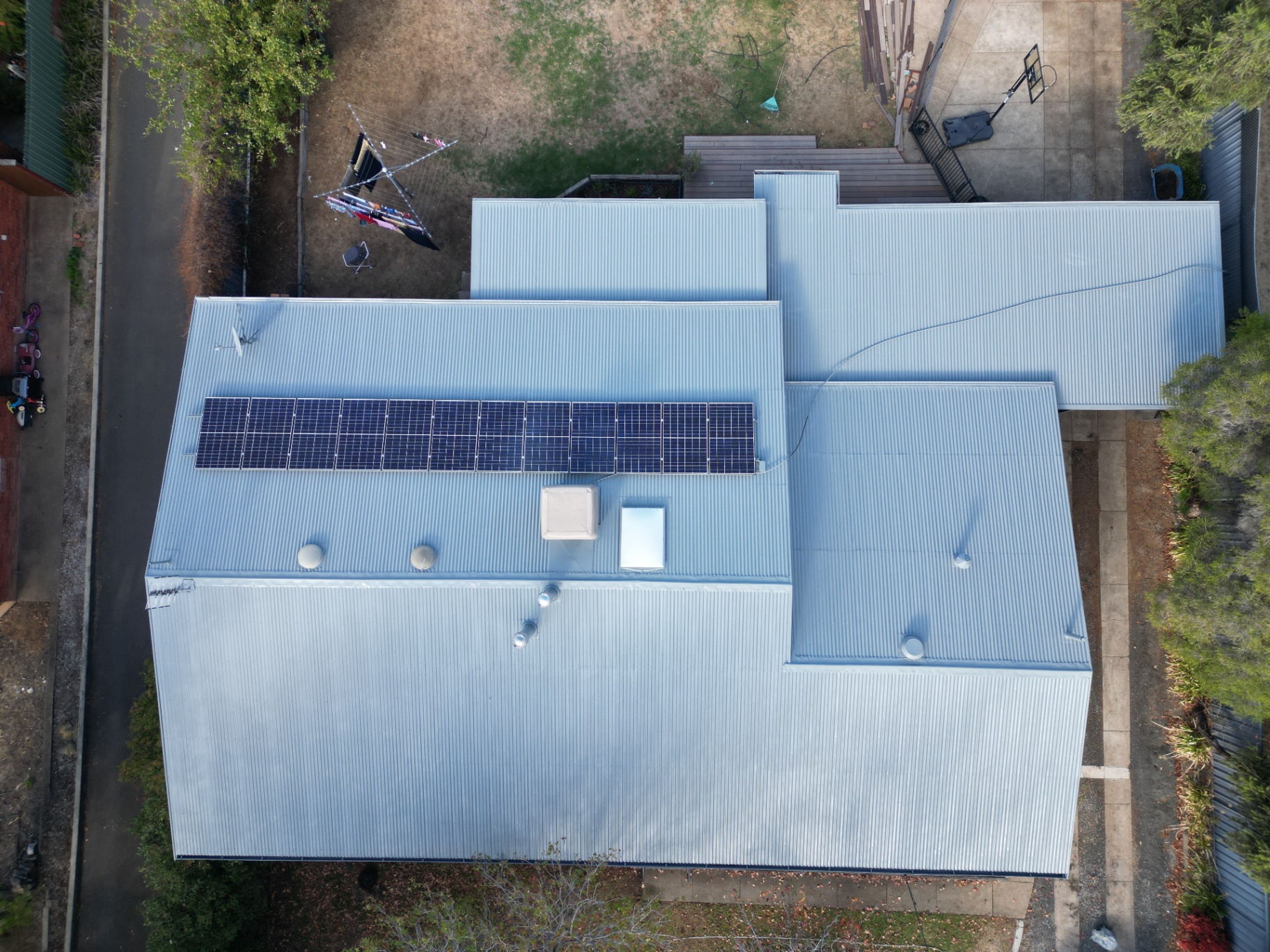 Top-Down Drone Photo of a Restored Silver Corrugated Metal Roof With Solar Panels