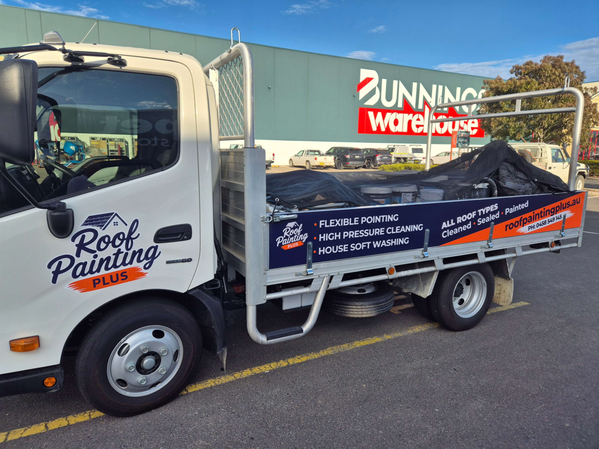 Signwritten Roof Painting Plus tipper truck loaded with paint at a Tamworth supplier