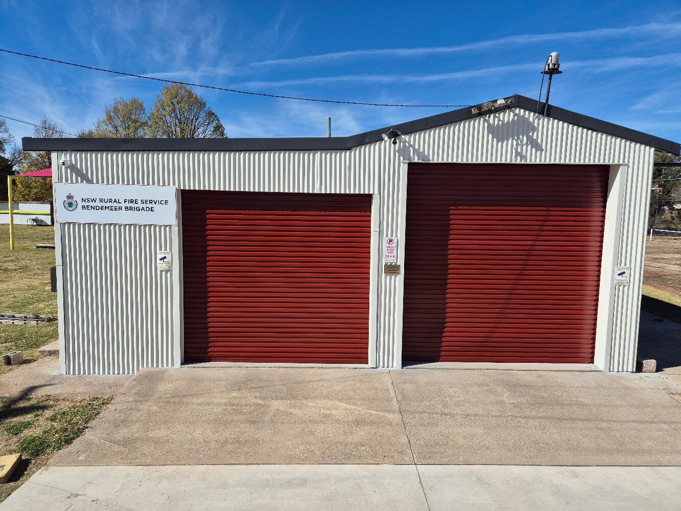 The Same Fire Shed After Repainting in Off-White With Red Roller Doors