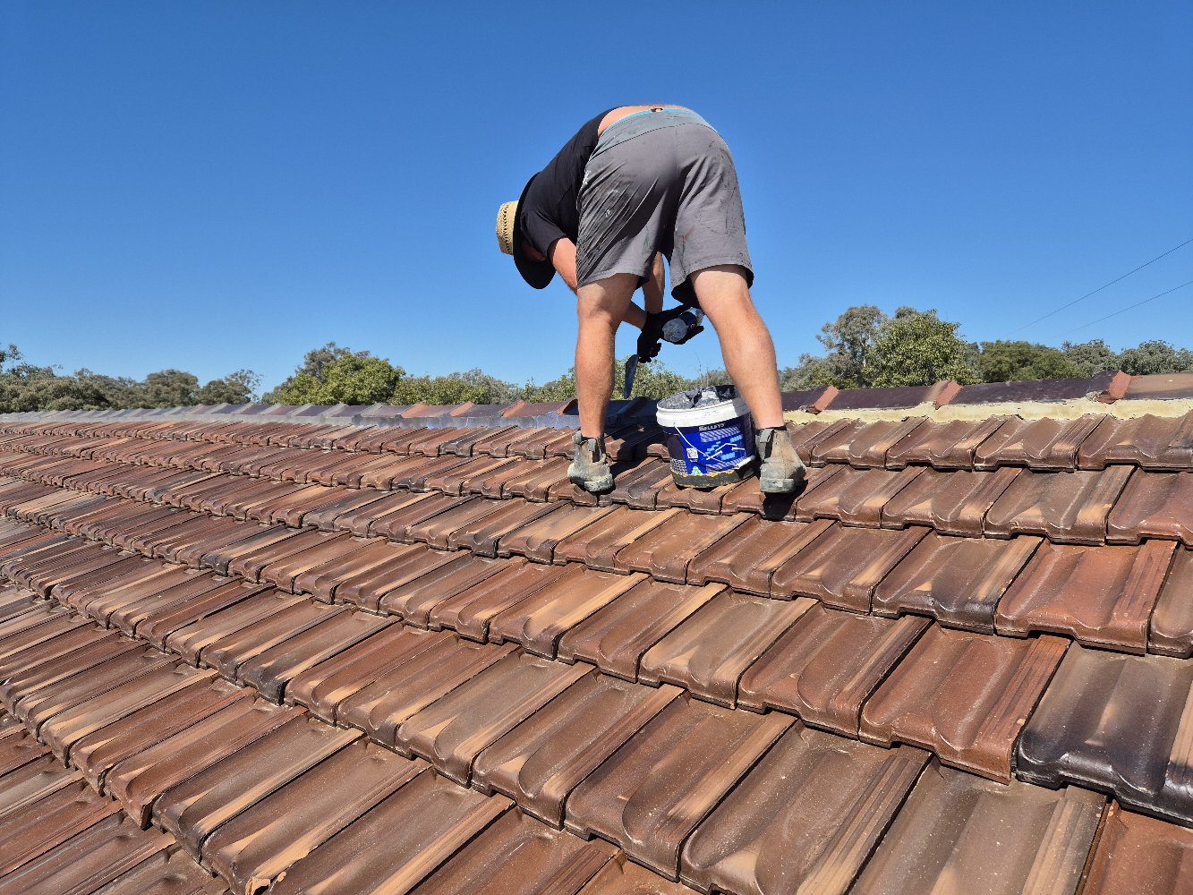 Colour-matched flexible pointing compound applied to tile roof ridge caps