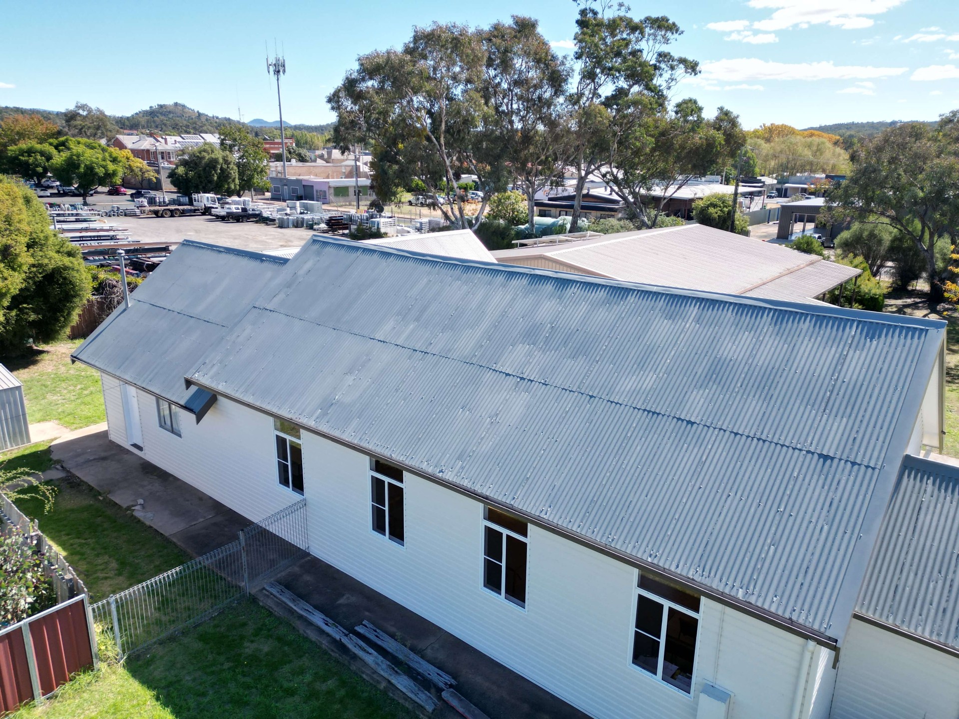 The same Coonabarabran metal roof after restoration, recoated in an even light grey finish